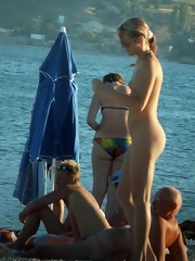Young nude beauty with perky boobs plays near the sea...